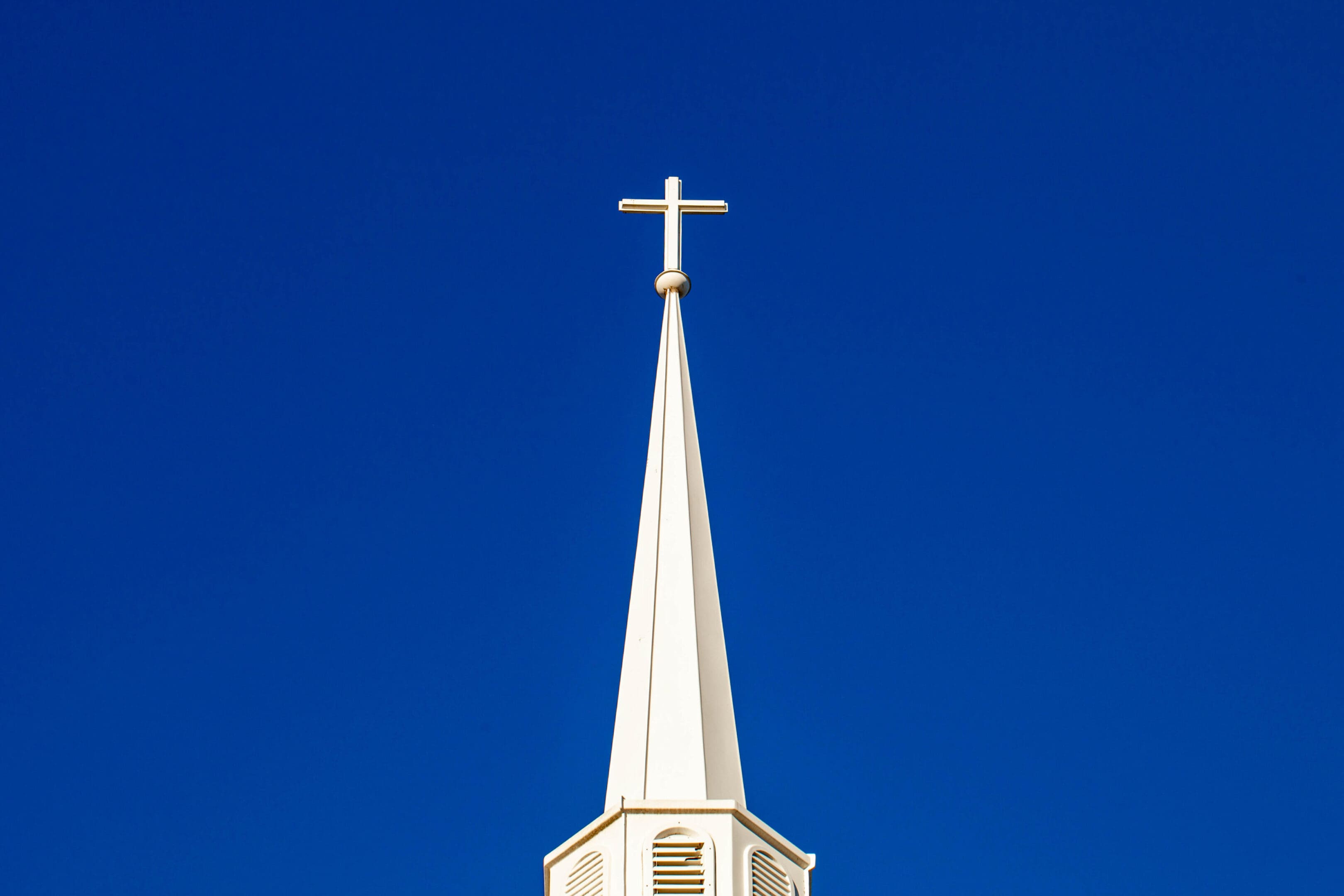 White cross on top of a steeple with copy space, horizontal